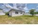 Well-maintained backyard featuring green grass, a white fence, and a covered patio with a barbecue grill at 600 Buchannan Dr, Davenport, FL 33837
