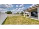 Expansive backyard with lush lawn, white picket fence, a covered patio and a barbecue grill at 600 Buchannan Dr, Davenport, FL 33837