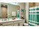 Cozy bathroom featuring a vanity, toilet, shower with curtain, and decorative mirror at 600 Buchannan Dr, Davenport, FL 33837