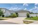 Single-story home with two-car garage, green shrubs, an expansive driveway and partial view of neighborhood at 600 Buchannan Dr, Davenport, FL 33837