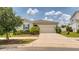 Attractive single-story home with two-car garage, green shrubs, and an expansive driveway at 600 Buchannan Dr, Davenport, FL 33837