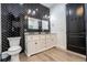 A stylish powder room features black herringbone tile and granite counters at 6917 Roman Ct, Clermont, FL 34714