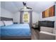 A light bedroom features a ceiling fan, a full bed, a dresser, a piece of art, and chairs at 6917 Roman Ct, Clermont, FL 34714
