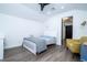 A small bedroom contains a ceiling fan, a twin bed, a side table, and a yellow armchair at 6917 Roman Ct, Clermont, FL 34714
