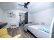 A quaint bedroom with a ceiling fan, a bed, a chair, and an ensuite visible through a door at 6917 Roman Ct, Clermont, FL 34714