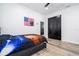 This bedroom features a gray bed frame, hardwood floors, and black closet doors for a modern and stylish look at 6917 Roman Ct, Clermont, FL 34714