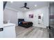 This bedroom features a gray bed frame, hardwood floors, a black ceiling fan, and a large mirror for a modern design at 6917 Roman Ct, Clermont, FL 34714