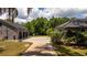 View of backyard with basketball hoop/garage and the home with solar panels on the roof at 6917 Roman Ct, Clermont, FL 34714