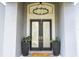 Elegant front entrance with double doors, modern light fixture, and decorative planters at 6917 Roman Ct, Clermont, FL 34714