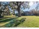 Beautiful one-story home with lush green lawn and mature shade trees in the front yard at 6917 Roman Ct, Clermont, FL 34714