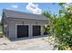 Three-car garage with black doors, complemented by a well-maintained driveway and landscape at 6917 Roman Ct, Clermont, FL 34714