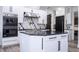 Modern kitchen features black granite countertops, stainless steel hood, and white cabinetry with black hardware at 6917 Roman Ct, Clermont, FL 34714