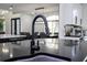 Close-up of kitchen sink with a black faucet and granite countertops, with views of the dining area in the background at 6917 Roman Ct, Clermont, FL 34714