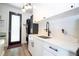Modern mudroom with white cabinets, black hardware, a sink, and a door to the outside at 6917 Roman Ct, Clermont, FL 34714