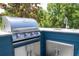 Outdoor kitchen with stainless steel grill and sink against blue cabinets, perfect for outdoor entertaining at 6917 Roman Ct, Clermont, FL 34714