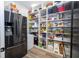 Walk-in pantry featuring stainless steel refrigerator and plentiful shelving for optimal organization at 6917 Roman Ct, Clermont, FL 34714