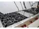 Close-up of a gas cooktop on an island with granite countertops at 6917 Roman Ct, Clermont, FL 34714
