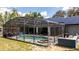 Screened-in pool area with an outdoor kitchen, hot tub, and solar panels on the house at 6917 Roman Ct, Clermont, FL 34714