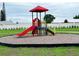 Neighborhood playground featuring a red play structure with slides and climbing elements on a mulch-covered area at 730 Ginger Dr, Haines City, FL 33844