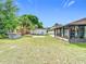 Spacious backyard featuring a shed, mature trees, and an enclosed patio, perfect for outdoor enjoyment at 7974 Village Green Rd, Orlando, FL 32818