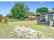 The backyard showcases mature trees, a shed, and a screened-in patio, providing an ideal outdoor living space at 7974 Village Green Rd, Orlando, FL 32818