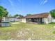 Large backyard featuring a sunroom, shed, lush grass, and mature trees at 7974 Village Green Rd, Orlando, FL 32818