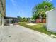 Spacious backyard showcasing a sunroom, lush grass, and a shed at 7974 Village Green Rd, Orlando, FL 32818