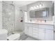 Updated bathroom with dual vanity, modern fixtures, walk-in shower with decorative tile, and sleek design at 7974 Village Green Rd, Orlando, FL 32818