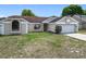 Inviting single-Gathering home featuring a manicured lawn, attached garage, and charming curb appeal with trees at 7974 Village Green Rd, Orlando, FL 32818