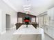 Open kitchen view with white quartz island and counters, stainless appliances, and a cozy living room view at 7974 Village Green Rd, Orlando, FL 32818