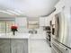 Contemporary kitchen boasts stainless steel appliances, white cabinetry, quartz countertops, and an island at 7974 Village Green Rd, Orlando, FL 32818