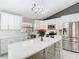 Bright kitchen featuring white cabinets, stainless appliances, stylish lighting, and a large island with seating at 7974 Village Green Rd, Orlando, FL 32818