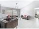 Bright living room with grey sofas, stylish lighting, and a large window providing natural light at 7974 Village Green Rd, Orlando, FL 32818