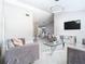 Open-concept living room featuring grey sofas, glass tables, modern lighting, and sleek white floors at 7974 Village Green Rd, Orlando, FL 32818