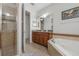 Well-appointed bathroom showcasing a shower, soaking tub, and wood cabinetry at 8067 Crushed Pepper Ave, Orlando, FL 32817