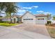Well-maintained home showcasing a brick driveway and a three-car garage at 8067 Crushed Pepper Ave, Orlando, FL 32817