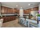 Spacious kitchen featuring dark wood cabinets, granite countertops, stainless steel appliances, and bar seating at 8067 Crushed Pepper Ave, Orlando, FL 32817