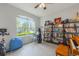 Bright and spacious room with a large window, desk, and shelves at 8067 Crushed Pepper Ave, Orlando, FL 32817