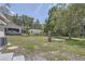 The spacious backyard features a small storage shed, lush trees, and a covered patio at 811 S Lone Oak Dr, Leesburg, FL 34748