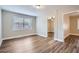 This bedroom features wood-look laminate flooring, a window and neutral paint at 811 S Lone Oak Dr, Leesburg, FL 34748