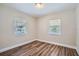 This bedroom features two windows and laminate flooring at 811 S Lone Oak Dr, Leesburg, FL 34748