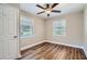 An ample bedroom features a modern ceiling fan, two windows, and attractive flooring at 811 S Lone Oak Dr, Leesburg, FL 34748