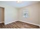 Bedroom features a window and wood look laminate flooring at 811 S Lone Oak Dr, Leesburg, FL 34748