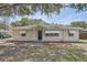 Charming single-story home with awnings, neutral paint, and a well-maintained front yard at 811 S Lone Oak Dr, Leesburg, FL 34748