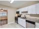 Bright kitchen features white cabinets, stainless steel appliances, and granite countertops at 811 S Lone Oak Dr, Leesburg, FL 34748