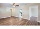 Cozy living room with wood-look floors, ceiling fan, and view to kitchen at 811 S Lone Oak Dr, Leesburg, FL 34748