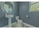 Charming powder room with a pedestal sink and blue walls at 8268 Bellow St, Orlando, FL 32827