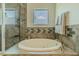 Bright bathroom showcasing a tub with gray tile and a decorative mosaic, offering a relaxing bathing experience at 8268 Bellow St, Orlando, FL 32827