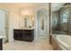 Bathroom featuring double sink vanity and tiled walk-in shower with a soaking tub at 8268 Bellow St, Orlando, FL 32827