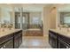 Bright bathroom featuring double vanity sinks, soaking tub, and glass enclosed shower at 8268 Bellow St, Orlando, FL 32827